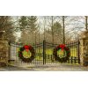 Custom driveway gate ideas. Wrought iron driveway swing gate in La Mesa, California with ornate toppers and two giant green wreaths that are adorned with red bows. 