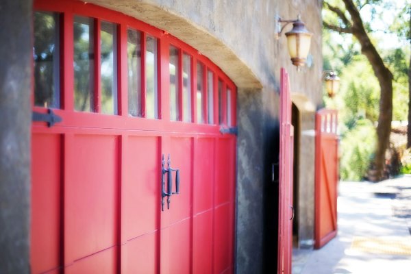 Red garage door with with 11 small windows and two black handles