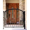black wrought iron gate in front of a wooden door, with stone archway surrounds, suggesting an elegant entryway to a home in San Diego, CA