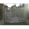 Gray security entry gate with vertical bars.